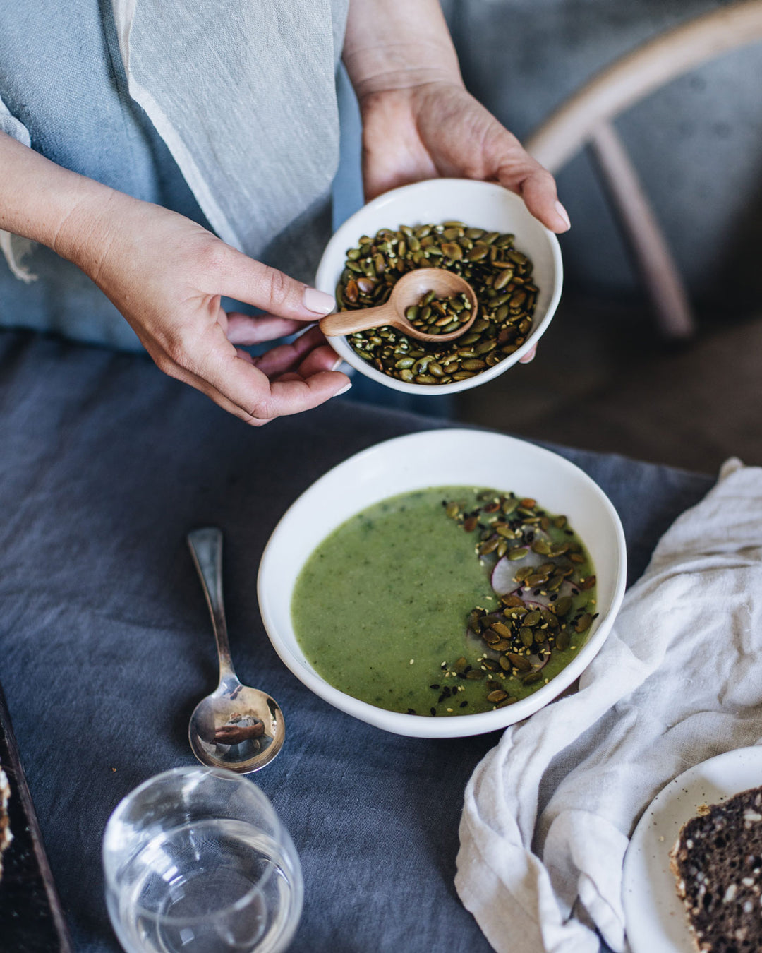 Winter pea and mint soup, sprinkled with pepitas in a stoneware handmade bowl