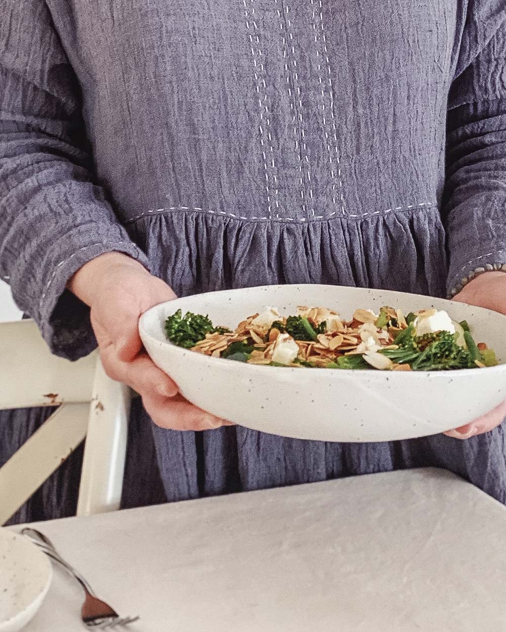 Eva Cassis holding a Winterwares ceramic bowl filled with broccoli salad