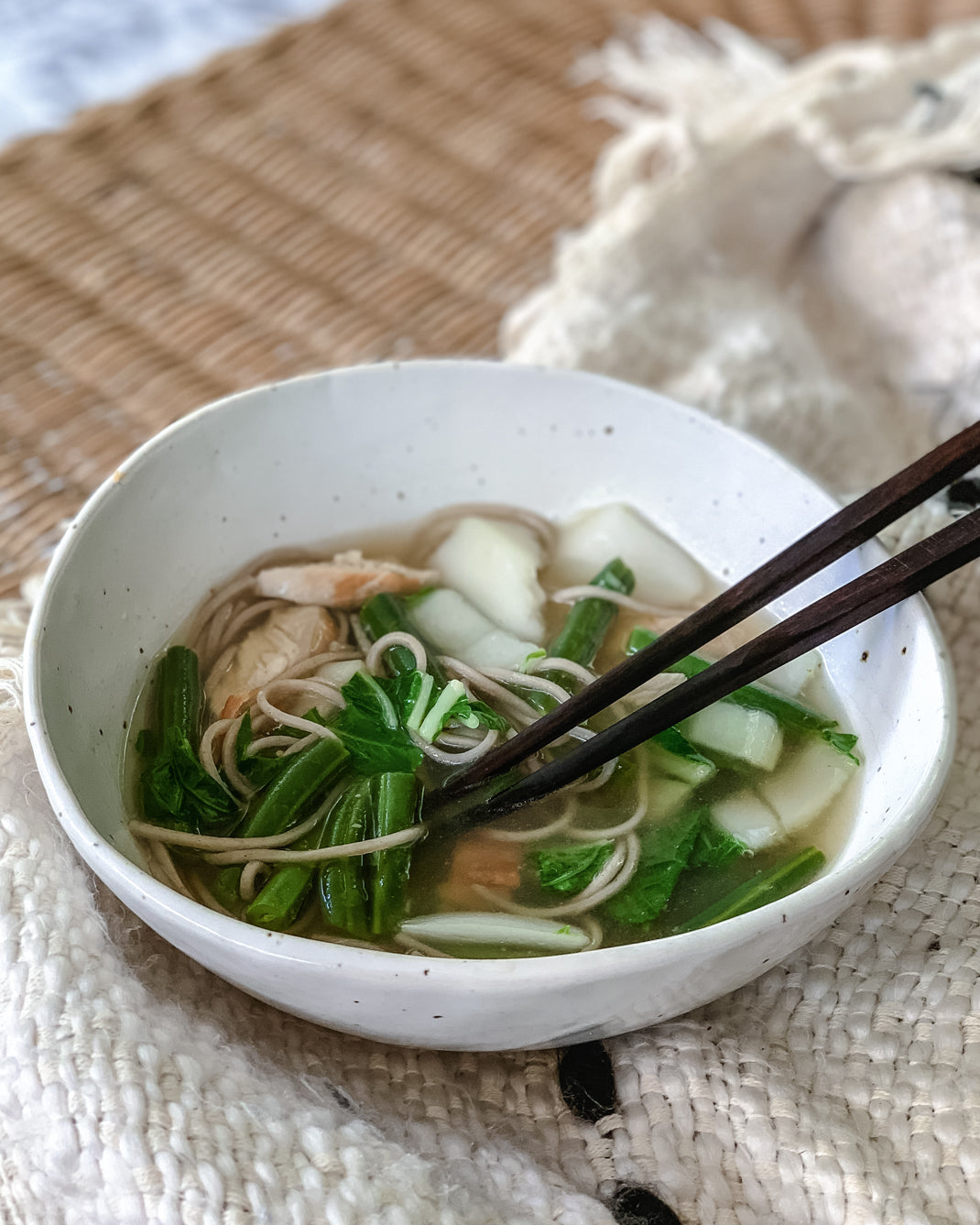 Chicken and soba noodle soup in a handmade ceramic bowl with bok choy