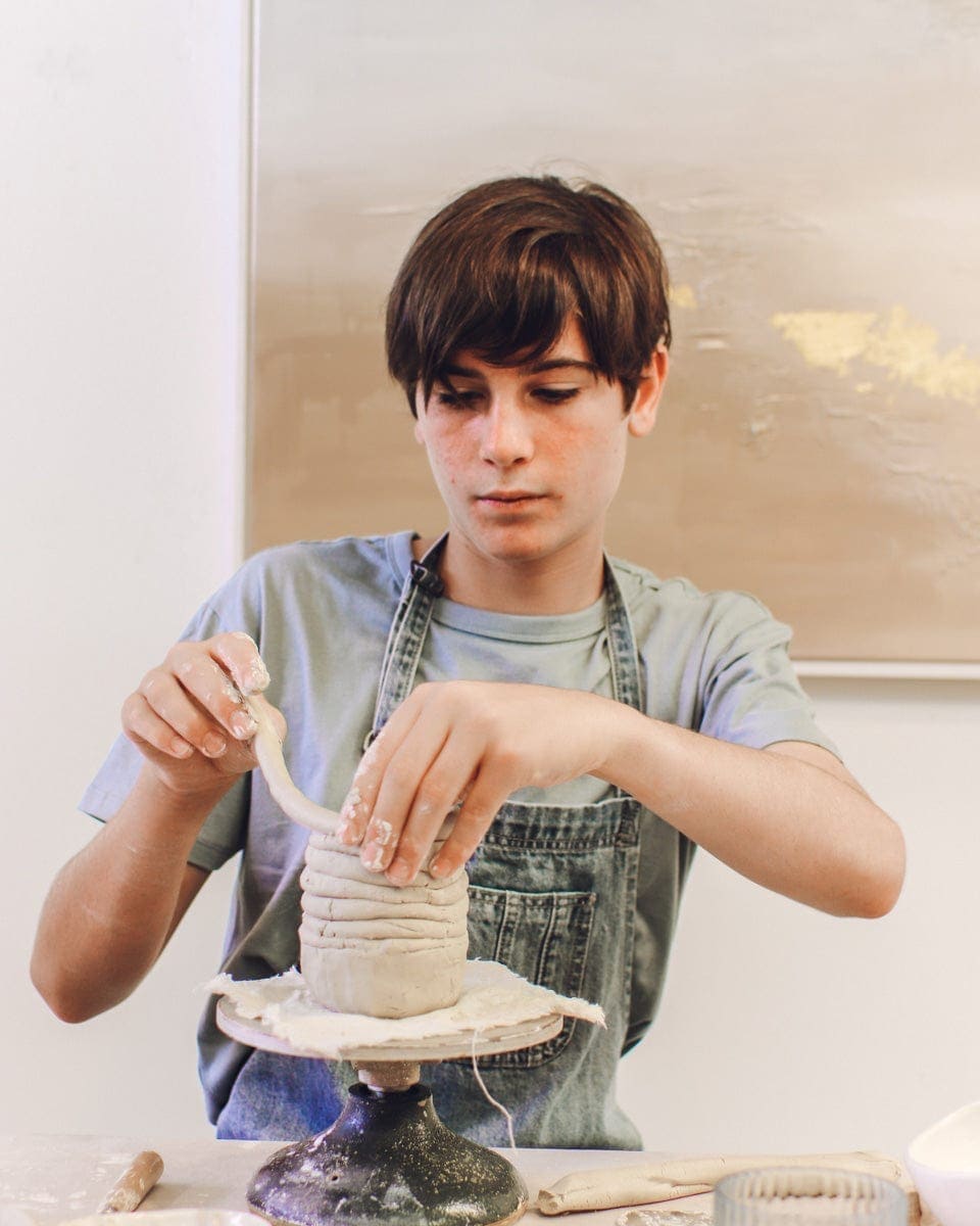 boy making a mug from clay