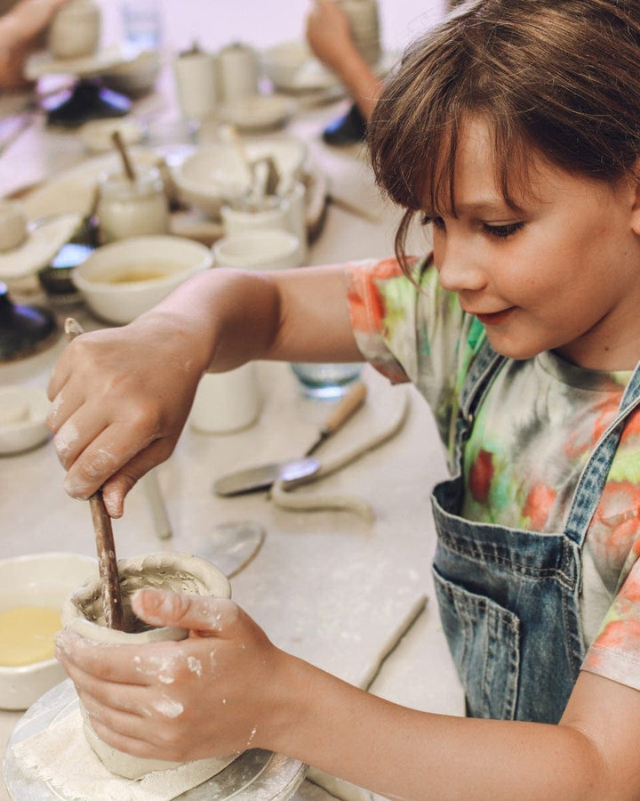 child making a mug from clay